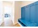 Inviting mudroom with built-in blue bench seating, storage cubbies, and coat hooks by front entrance at 1004 Loganberry Ln, Salisbury, NC 28146