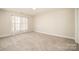 Spacious bedroom features neutral walls, carpet, and a large window that allows for plenty of natural light at 10142 Linksland Dr, Huntersville, NC 28078