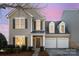 Charming two-story home featuring a welcoming front porch and a well-maintained lawn with mature landscaping at 10142 Linksland Dr, Huntersville, NC 28078