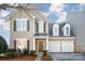 Charming two-story home featuring a welcoming front porch and a two-car garage in a well-manicured lawn at 10142 Linksland Dr, Huntersville, NC 28078