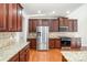 Modern kitchen featuring stainless steel appliances, granite countertops, and rich wood cabinets at 10142 Linksland Dr, Huntersville, NC 28078