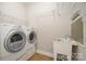 Bright laundry room featuring a washer, dryer, utility sink, and convenient overhead shelving for ample storage at 10142 Linksland Dr, Huntersville, NC 28078