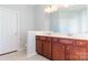 Well-lit bathroom showcasing double vanity, wooden cabinets, and neutral tile flooring at 10546 Tintinhull Dr, Indian Land, SC 29707