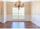 Elegant dining room featuring hardwood floors, wainscoting, and a decorative chandelier at 10546 Tintinhull Dr, Indian Land, SC 29707