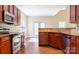 Modern kitchen with stainless steel appliances and rich wood cabinets and light backsplash at 10546 Tintinhull Dr, Indian Land, SC 29707