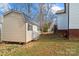 Backyard storage shed with a durable, metal roof, positioned near the house and rock formation in the background at 1275 Rocky Ridge Trl, Salisbury, NC 28146
