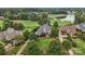 Aerial view showcases a well-manicured lawn and lush landscaping surrounding a grand estate on the golf course at 145 Milford Cir, Mooresville, NC 28117
