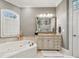 Stylish bathroom featuring a soaking tub, large vanity with framed mirror, and walk-in shower at 145 Milford Cir, Mooresville, NC 28117