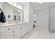 Bright bathroom featuring double sinks, white cabinetry, and a glass door shower at 145 Milford Cir, Mooresville, NC 28117