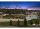 Scenic golf course view with a serene lake, complemented by a beautiful sunset backdrop and a stately home at 145 Milford Cir, Mooresville, NC 28117