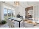 Bright office space with a large window overlooking the yard, glass top desk, and elegant chandelier at 145 Milford Cir, Mooresville, NC 28117