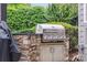 A stainless steel outdoor grill is built into a stone structure and surrounded by greenery at 145 Milford Cir, Mooresville, NC 28117