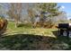 Backyard featuring a gentle slope, mature trees, and a grill perfect for outdoor cooking at 18016 Bluff Inlet Rd, Cornelius, NC 28031