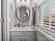 Cozy bathroom featuring a vanity with an oval mirror and natural light from a window at 18016 Bluff Inlet Rd, Cornelius, NC 28031