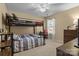 Neutral toned bedroom featuring a bunk bed, a desk, and a window for natural light at 18016 Bluff Inlet Rd, Cornelius, NC 28031