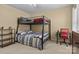 Neutral toned bedroom featuring a bunk bed, desk, ceiling fan, and dresser at 18016 Bluff Inlet Rd, Cornelius, NC 28031