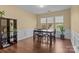 Traditional dining room with dark wood floors and large windows allowing natural light to illuminate the space at 18016 Bluff Inlet Rd, Cornelius, NC 28031