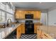 Traditional kitchen with wood cabinets, black appliances, an island, and granite countertops at 18016 Bluff Inlet Rd, Cornelius, NC 28031