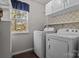 Efficient laundry room with white washer and dryer and white upper cabinets and shelving at 18016 Bluff Inlet Rd, Cornelius, NC 28031