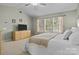 Bright primary bedroom featuring a large window and a dresser at 18016 Bluff Inlet Rd, Cornelius, NC 28031