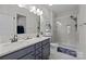 Bathroom features dual sinks, a tiled shower, and neutral gray paint at 201 Bennett Trail Dr, Mount Holly, NC 28120