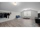 Bright bonus room with wood-look flooring, a blue sofa, and a lounge space for a pet at 201 Bennett Trail Dr, Mount Holly, NC 28120