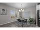 Cozy dining area with a modern table, clear chairs, a stylish chandelier, and natural light from the window at 201 Bennett Trail Dr, Mount Holly, NC 28120