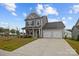 Charming gray two-story home with a two-car garage and a welcoming front porch at 201 Bennett Trail Dr, Mount Holly, NC 28120