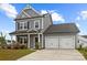Charming gray two-story home with a two-car garage and a welcoming front porch at 201 Bennett Trail Dr, Mount Holly, NC 28120