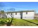 Backyard showcasing a lush lawn, a small deck, and a gray exterior elevation at 205 Mauney St, Mount Holly, NC 28120