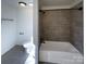 Bathroom featuring tiled shower and floors, white walls and modern fixtures at 205 Mauney St, Mount Holly, NC 28120
