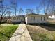 Charming one-story home featuring a well-maintained lawn and a concrete walkway leading to the front entrance at 205 Mauney St, Mount Holly, NC 28120