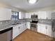 Updated kitchen with white cabinets, stainless steel appliances, stone countertops and hardwood floors at 205 Mauney St, Mount Holly, NC 28120