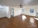 Spacious living room featuring hardwood floors, neutral walls, ceiling fan and two bright windows at 205 Mauney St, Mount Holly, NC 28120