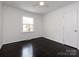 Empty bedroom featuring a ceiling fan, dark wood floors, and a large window at 2286 Kilborne Dr, Charlotte, NC 28205