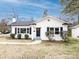 Charming exterior of home featuring a white brick facade, black shutters and door, and manicured landscaping at 2286 Kilborne Dr, Charlotte, NC 28205