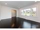 A spacious room with dark hardwood floors, freshly painted walls, and large windows offering natural light at 2286 Kilborne Dr, Charlotte, NC 28205