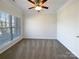 Bright, carpeted bedroom with a ceiling fan, large window, and neutral decor at 235 Glenville Dr, Fort Mill, SC 29715