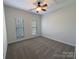 Well-lit bedroom with neutral carpet, ceiling fan, and two windows at 235 Glenville Dr, Fort Mill, SC 29715