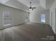 Unfurnished primary bedroom with tray ceiling, three windows, and neutral carpeting at 235 Glenville Dr, Fort Mill, SC 29715
