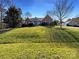 Inviting brick home with a manicured lawn and mature trees under a bright blue sky at 235 Glenville Dr, Fort Mill, SC 29715