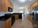 Functional kitchen with black appliances, tile flooring, and ample cabinet space at 235 Glenville Dr, Fort Mill, SC 29715