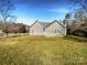 Rear exterior view with a large manicured lawn and sunroom on a sunny day at 235 Glenville Dr, Fort Mill, SC 29715