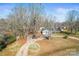 Aerial view of the home showcasing its landscaped yard, mature trees, and expansive driveway leading to the garage at 2659 Surrey Dr, Lincolnton, NC 28092