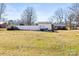 A large yard with green grass and a tall, white fence and a shed with outside furniture at 2659 Surrey Dr, Lincolnton, NC 28092