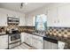 Functional kitchen with white cabinets, stainless steel appliances, and tile backsplash at 2659 Surrey Dr, Lincolnton, NC 28092