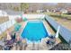 Backyard in-ground pool is surrounded by a concrete deck, white fence, and an array of patio furniture at 2659 Surrey Dr, Lincolnton, NC 28092