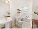 A bright, clean bathroom with a single sink vanity, shower-tub combo, and floating shelves at 2988 Clover Nw Rd, Concord, NC 28027