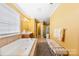 Bathroom with a tub, double sink vanity, walk-in shower, and bench at 2988 Clover Nw Rd, Concord, NC 28027