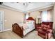 Cozy bedroom features a tray ceiling, neutral walls and a comfortable recliner at 305 Chancelot Ln, Fort Mill, SC 29708